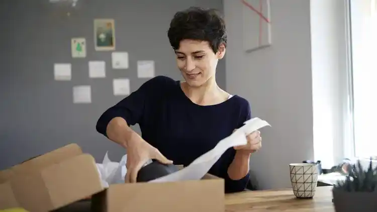 Mujer empacando una caja para UPS