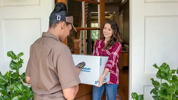 Mujer entregando el paquete al conductor en la puerta