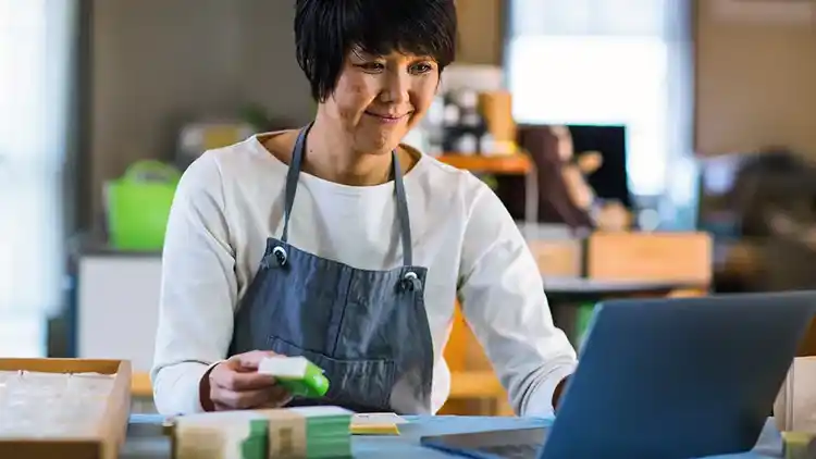 Mujer usando UPS Delivery Intercept en su computadora portátil