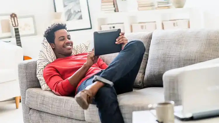 Hombre en sofá viendo una iPad